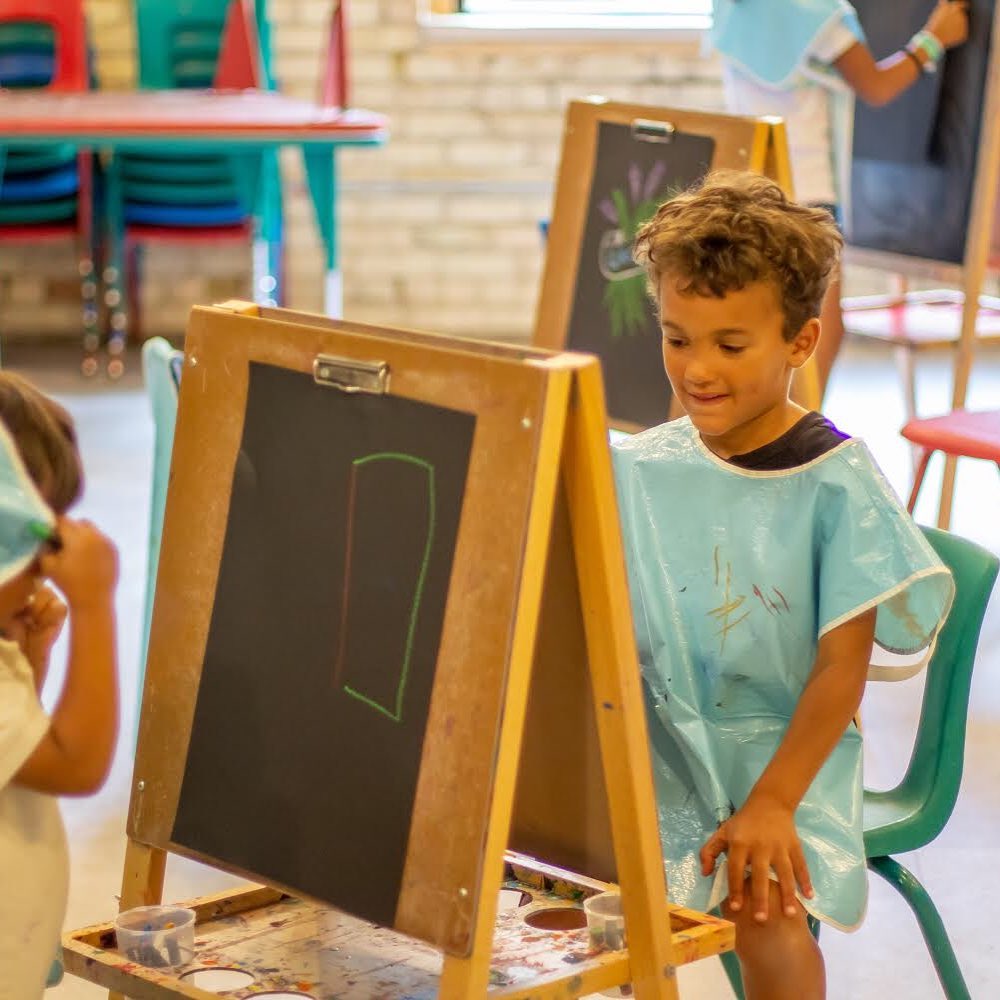 Child painting at an easel at the Grand Rapids Childrens Museum. Photo by Instagram user @grcmuseum