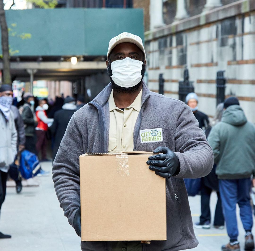 Volunteer in a COVID-19 mask delivers a box of food. Photo by Instagram user @feedingamerica