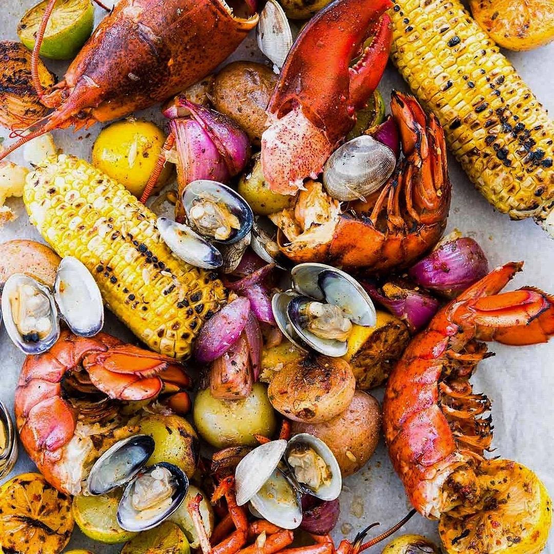 Spread of Rat's Restaurant's annual Lobster Clambake, including lobster tail and claw, corn-on-the-cob, clams, and potatoes. Photo by Instagram user @rats.restaurant