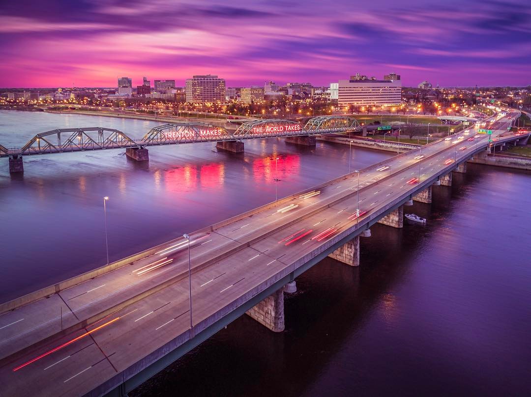 Drone photo of twilight time lapse of Downtown Trenton, NJ, featuring the famous "Trenton Makes, the World Takes" sign alit on the bridge. Photo by Instagram user @fotosforthefuture_drone 