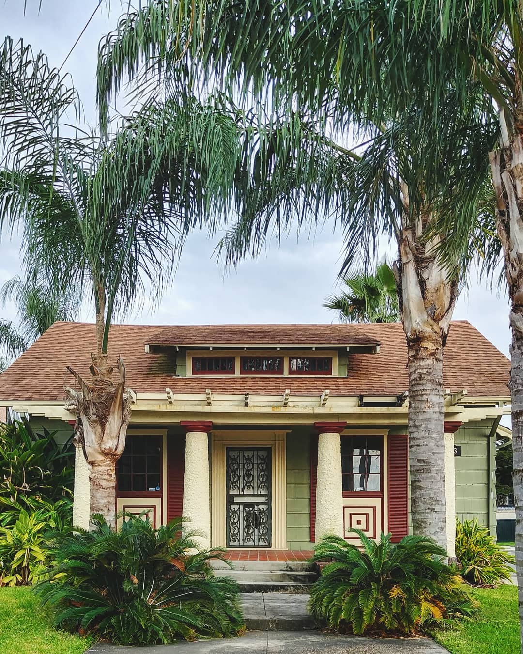 Green bungalow-style home with pillars and palm trees in Fillmore neighborhood. Photo by Instagram user @m.dallemolle