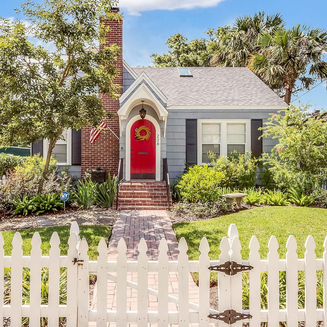 Small Bungalow Home with Red Door and White Picket Fence. Photo by Instagram user @pattypixley