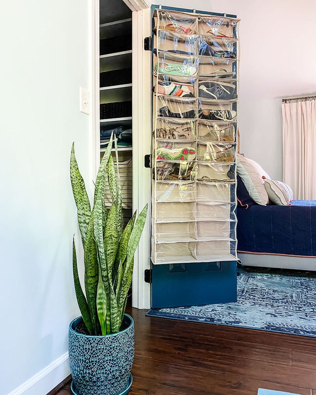 An over-the-door shoe organizer hangs from a closet door.