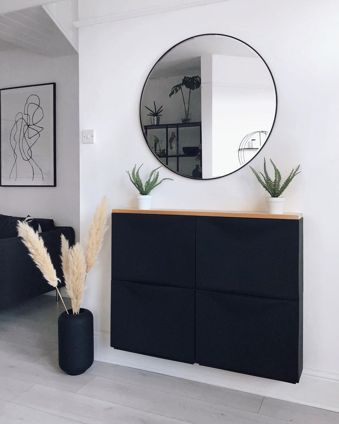 Sleek black shoe cabinet hanging on a wall.