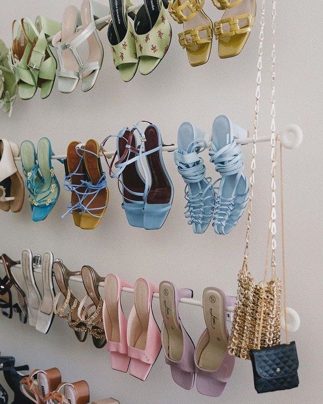 Heels hanging on curtain rods in a closet.