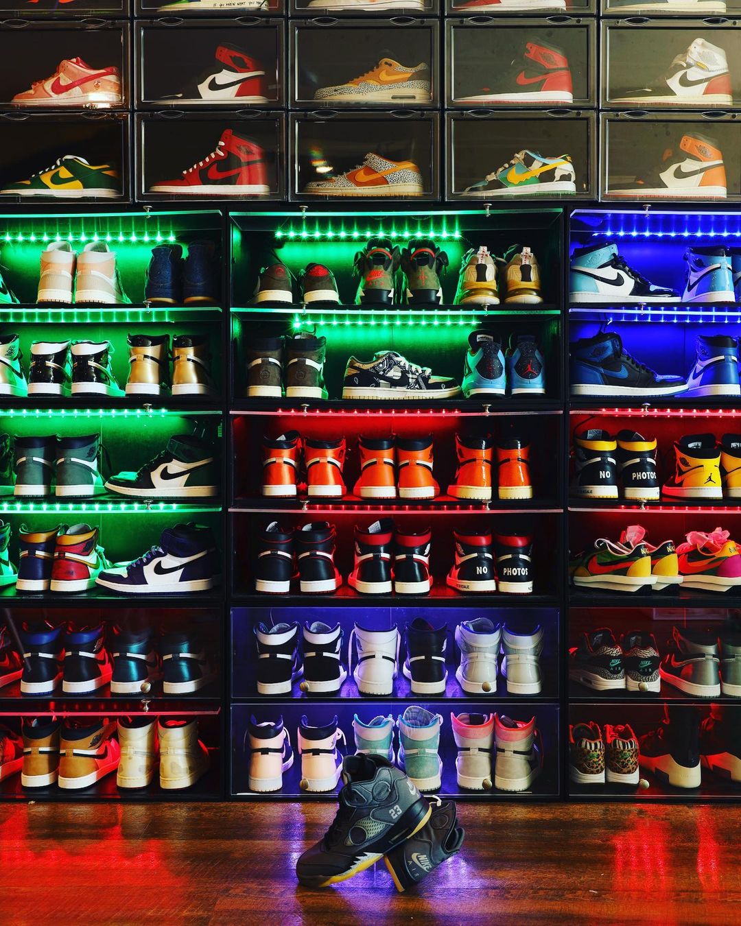 Colorful sneakers organized on shoe racks.