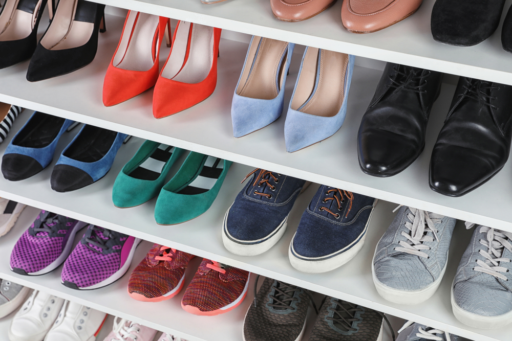 Multicolored shoes stored on white shelves.