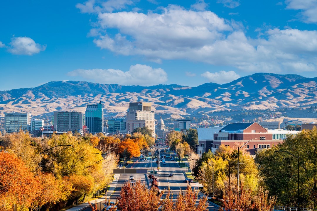 View of Boise, with mountains and Downtown in the background and trees changing color. Photo by Instagram user @visitboise.