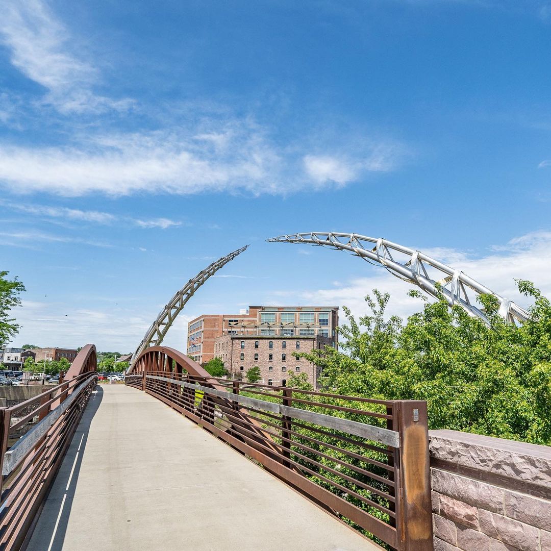 Photo of Sioux Falls' Arc of Dreams with a building positioned in the open space of the sculpture. Photo by Instagram user @inrealtygrp.