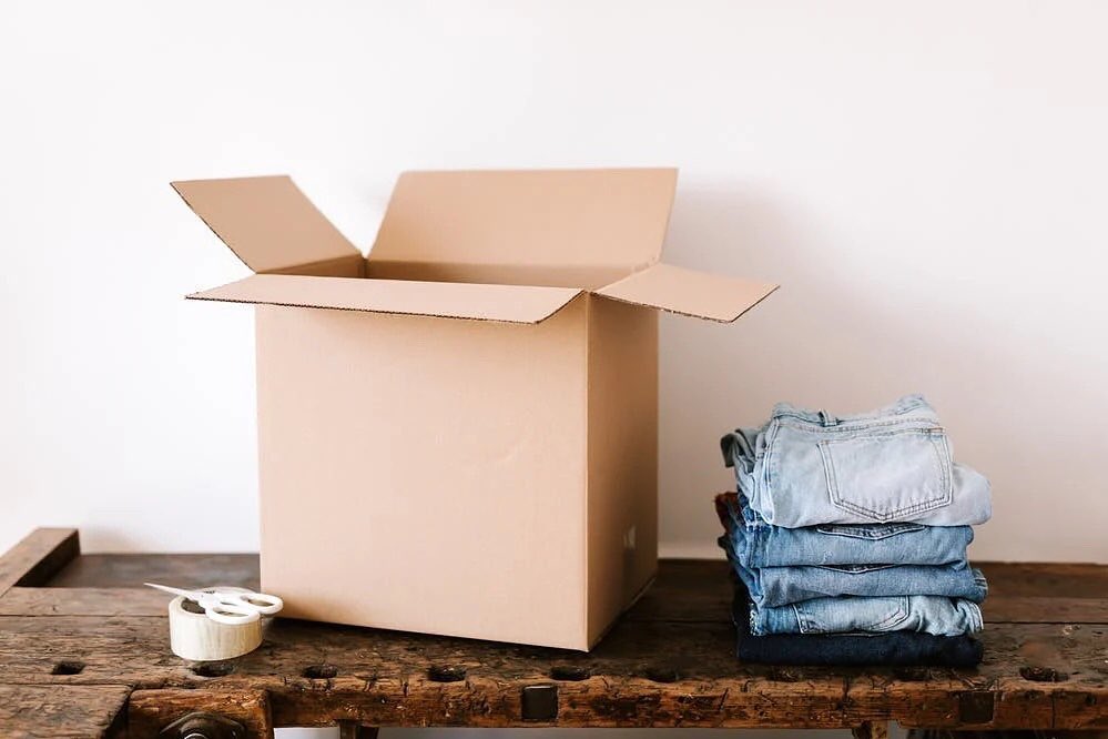 Medium box open beside a stack of jeans. Photo by Instagram user @setapartstyle.