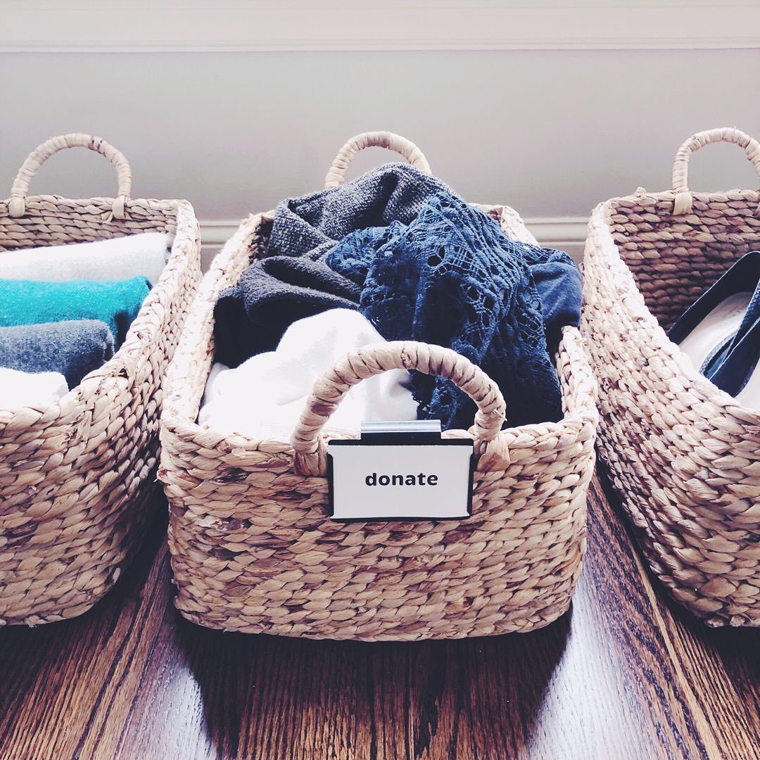 Baskets with decluttered objects in them; the middle basket says "donate." Photo by Instagram user @neatlittlenest.