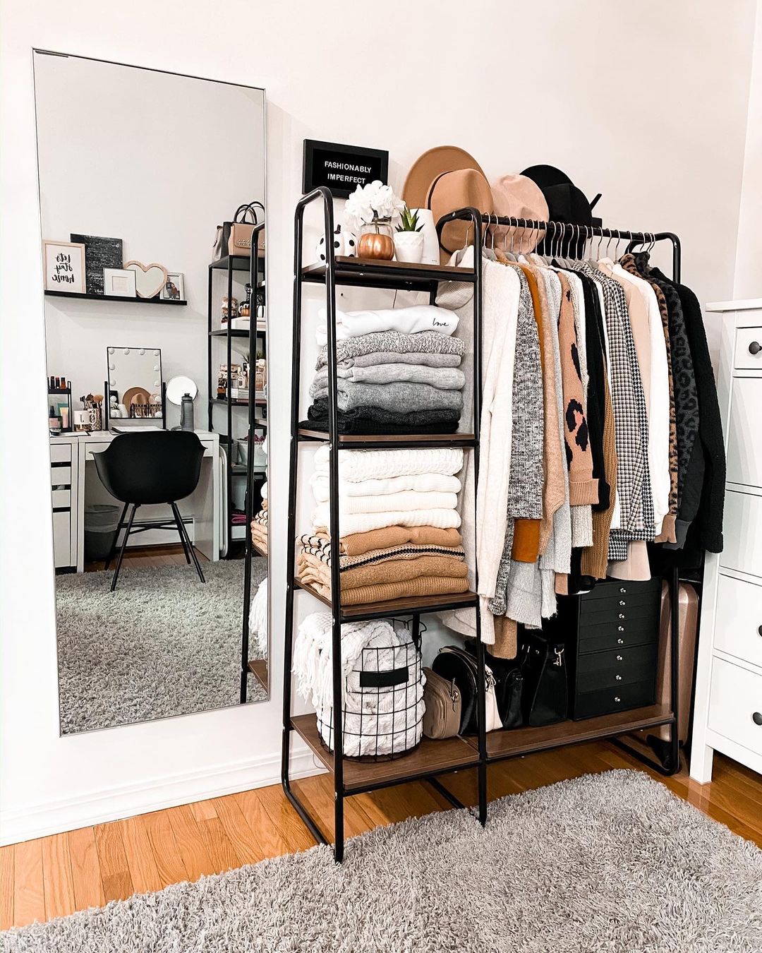 Clothing rack full with hanging clothes, and the shelves are full with clothes and other items as well. Photo by Instagram user @fashionablyimperfect.