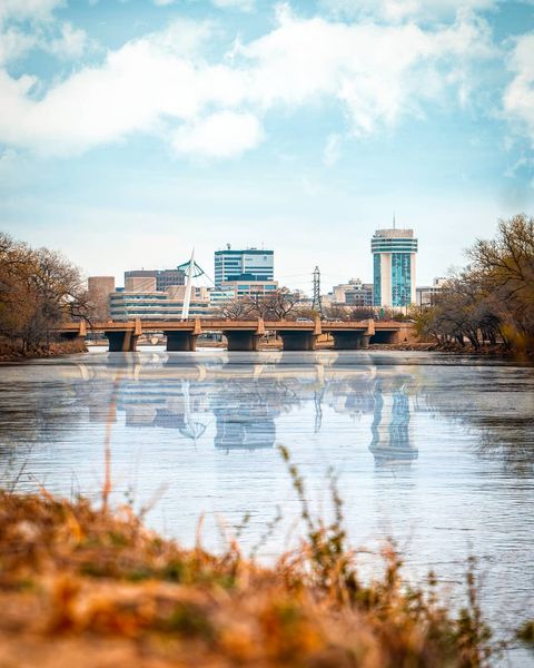Skyline view of downtown Wichita, KS from across the water. Photo by Instagram user @scotthuynhdesign.