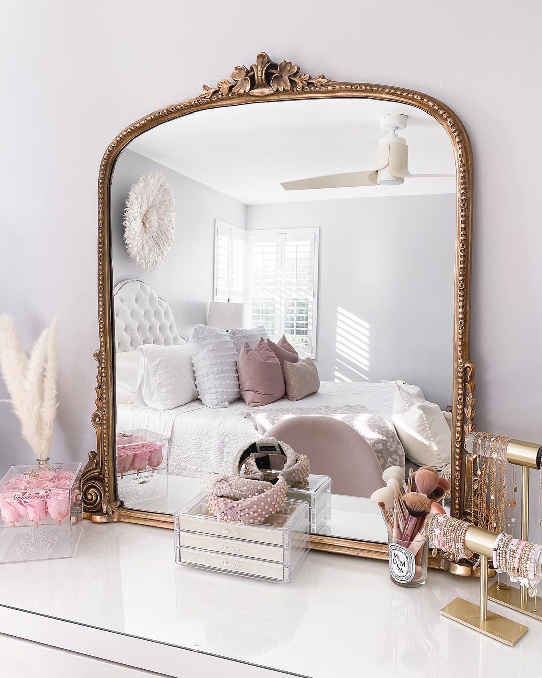 Large mirror with decorative brass finish sitting on dresser. Photo by Instagram User @fancythingsblog
