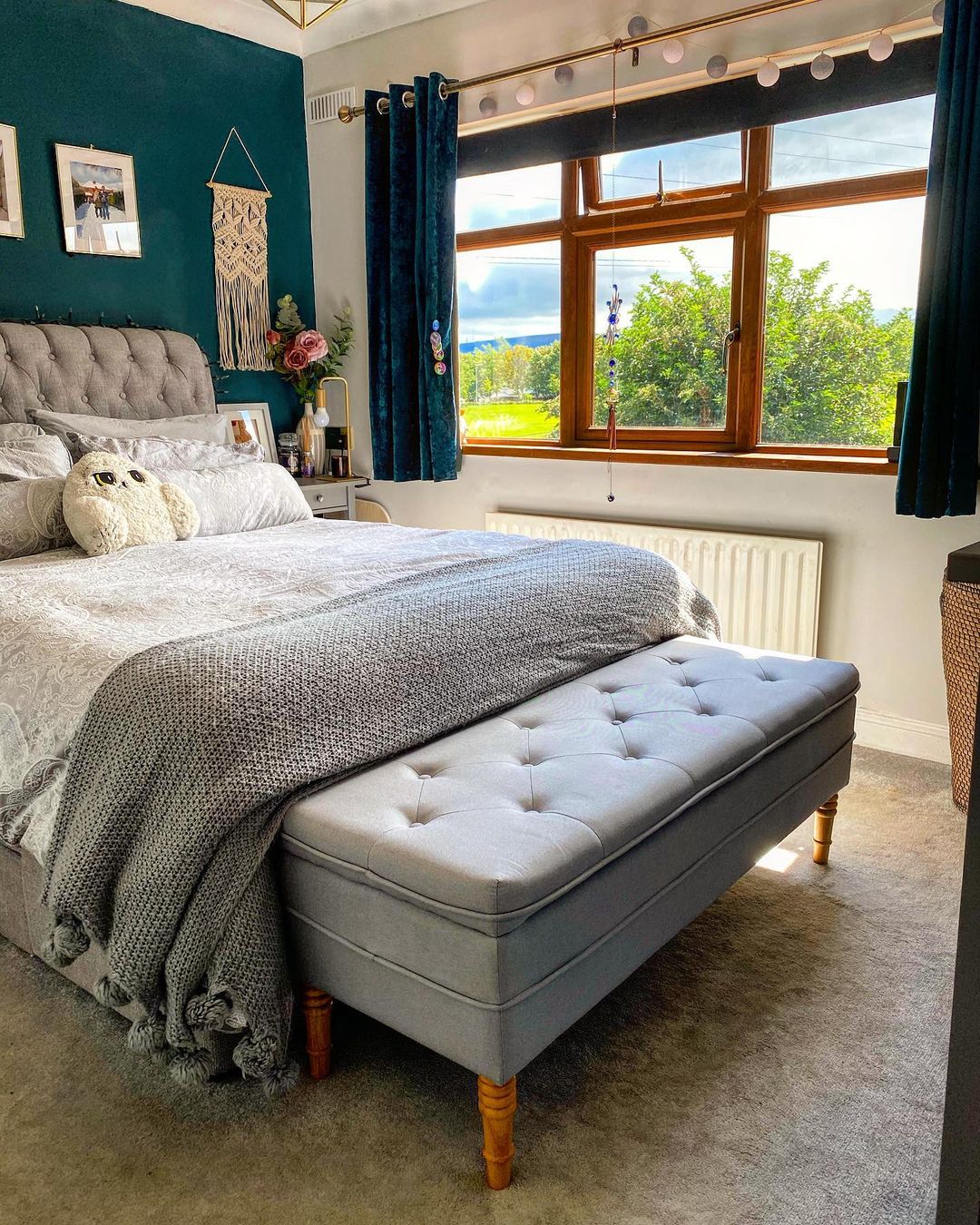 Tufted gray fabric bench at the foot of the bed. Photo by Instagram User @sprucingupthegaff