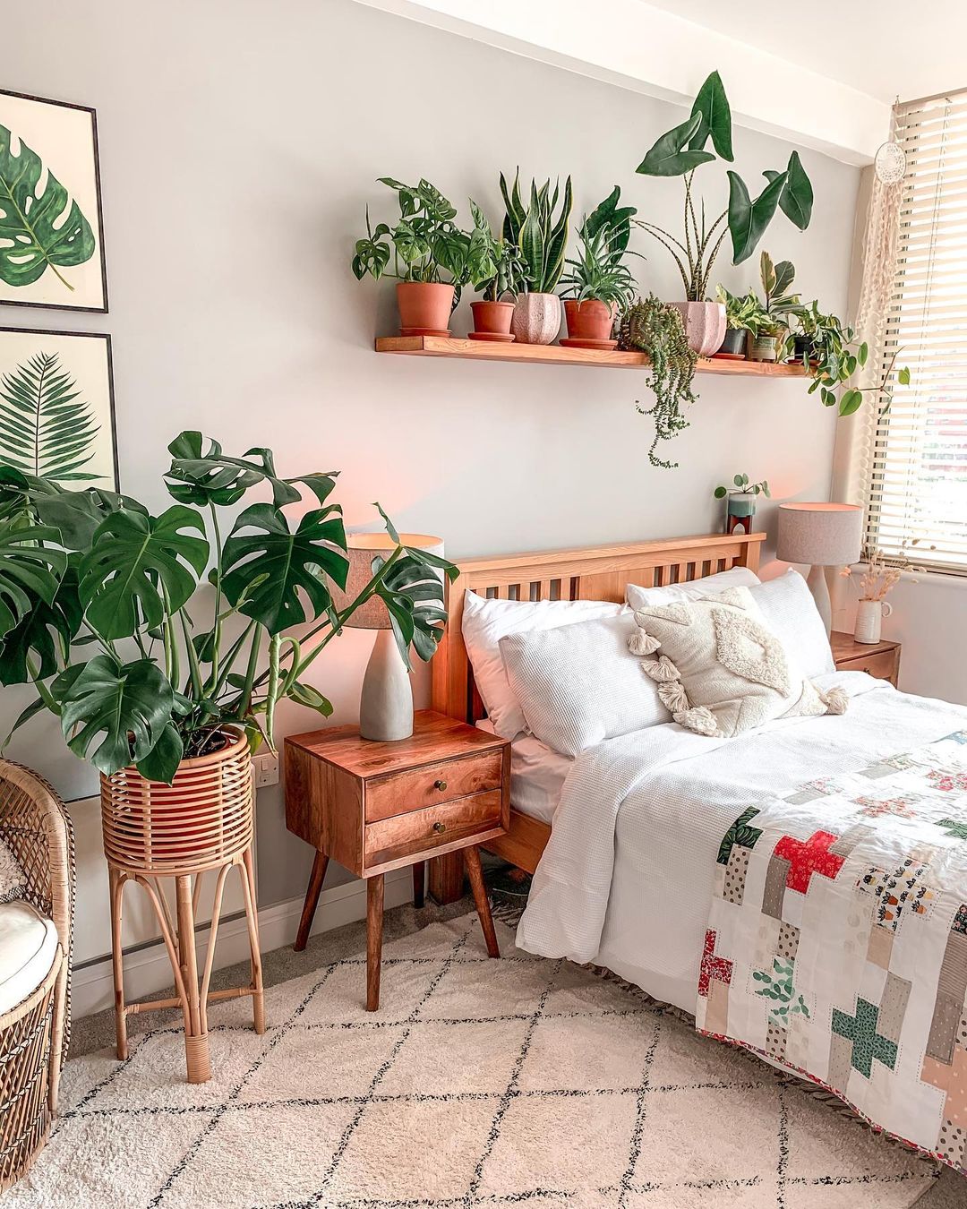 A variety of plants in planters and on shelves in the bedroom. Photo by Instagram User @themacramejungle