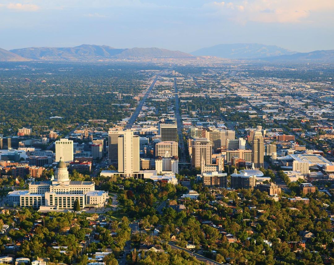 Wide aerial view of downtown Salt Lake City with the mountain in the background. Photo by Instagram user @lukedavphoto