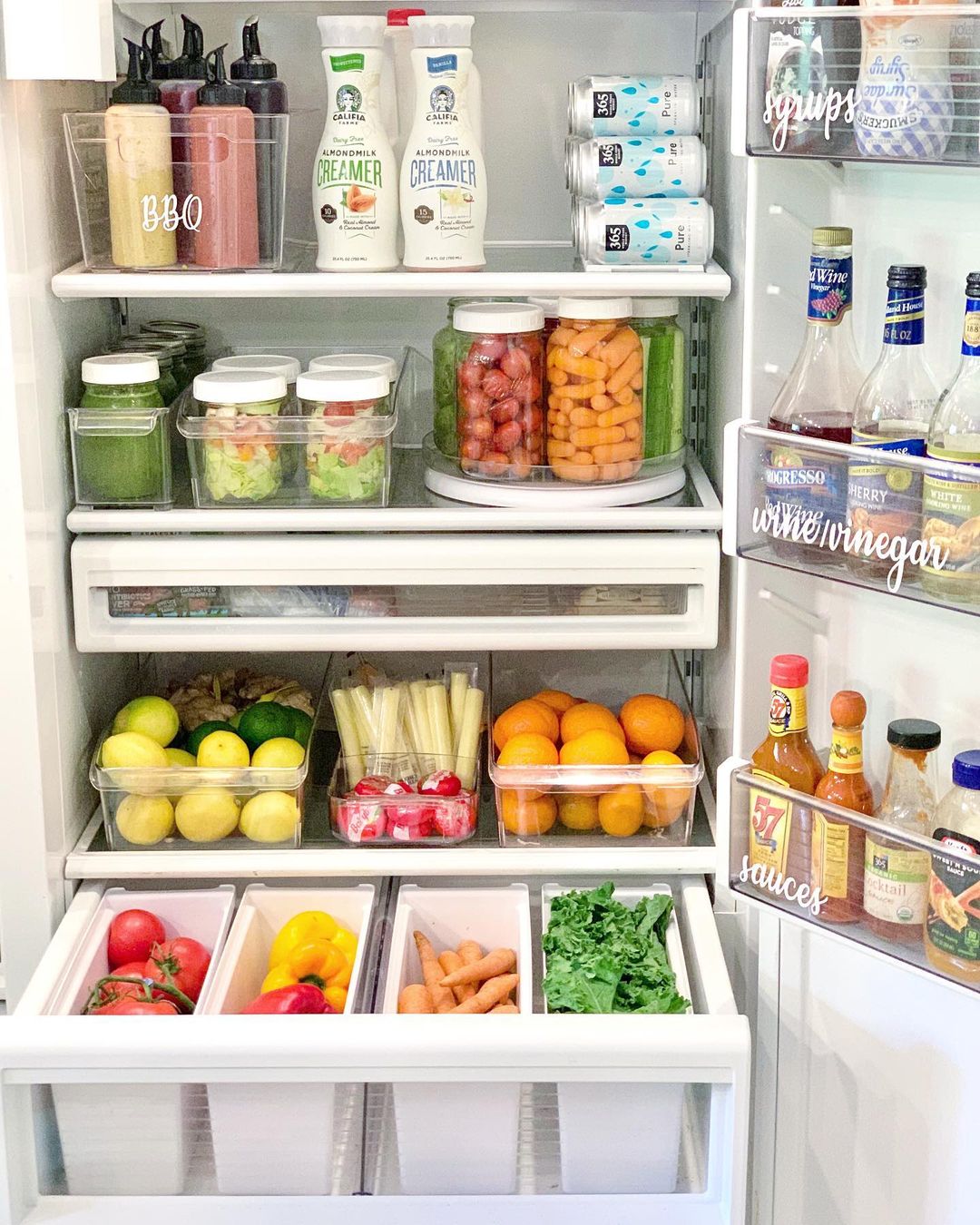 Neatly organized fridge that uses plastic bins. Photo by Instagram user @livecomposed