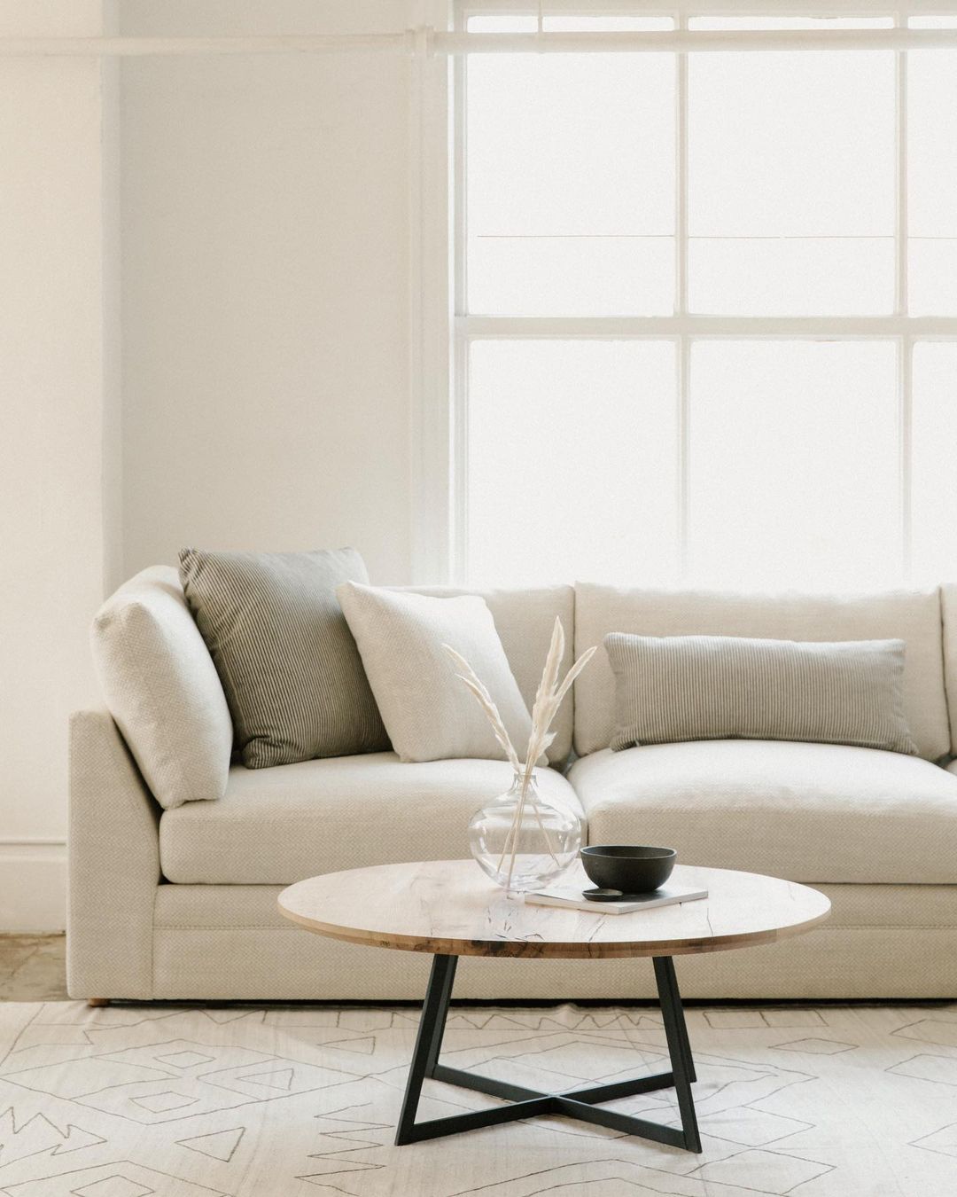 Neatly decluttered coffee table in front of a couch. Photo by Instagram user @sundaysfurniture