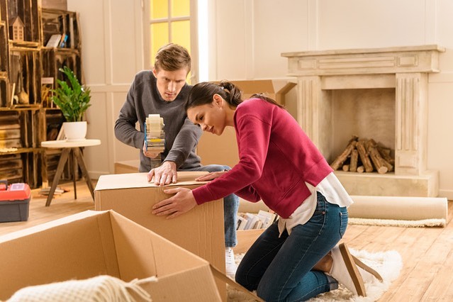 Couple taping a moving box while packing a house. Photo by Instagram user @ourtownamerica