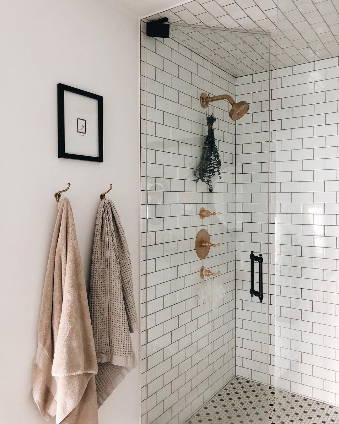 Tiled shower with a glass shower door. Photo by @withjustine