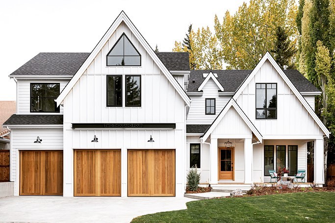 Large new construction home with white, modern farmhouse exterior. Photo by Instagram User @tricklecreekyyc