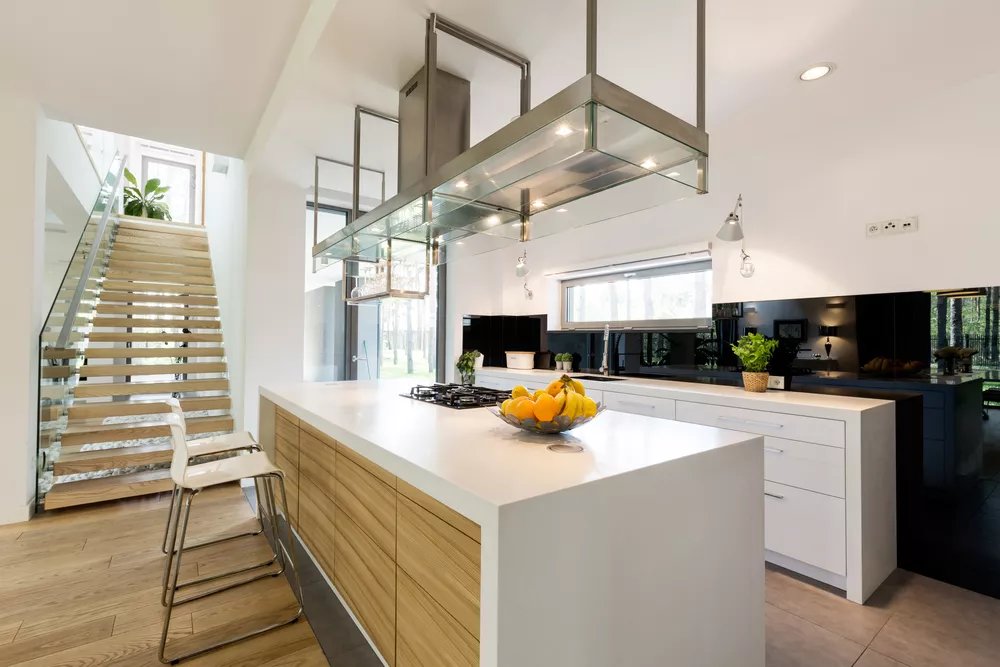 Modern white kitchen with wood accents and large kitchen island.