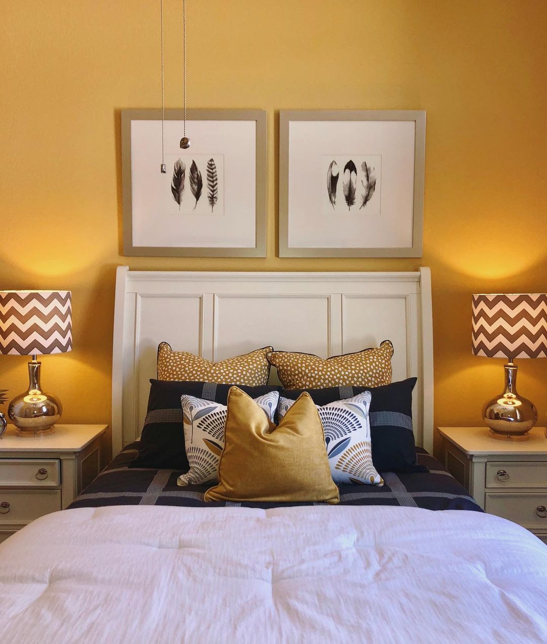 Head-on view of the bed, which has accent pillows that match the Butter Yellow walls.