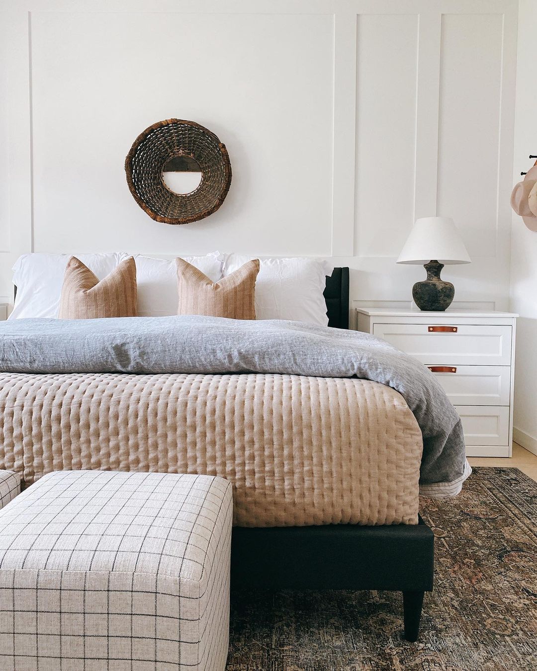 Bedroom with cloud white walls and peach bed linens.