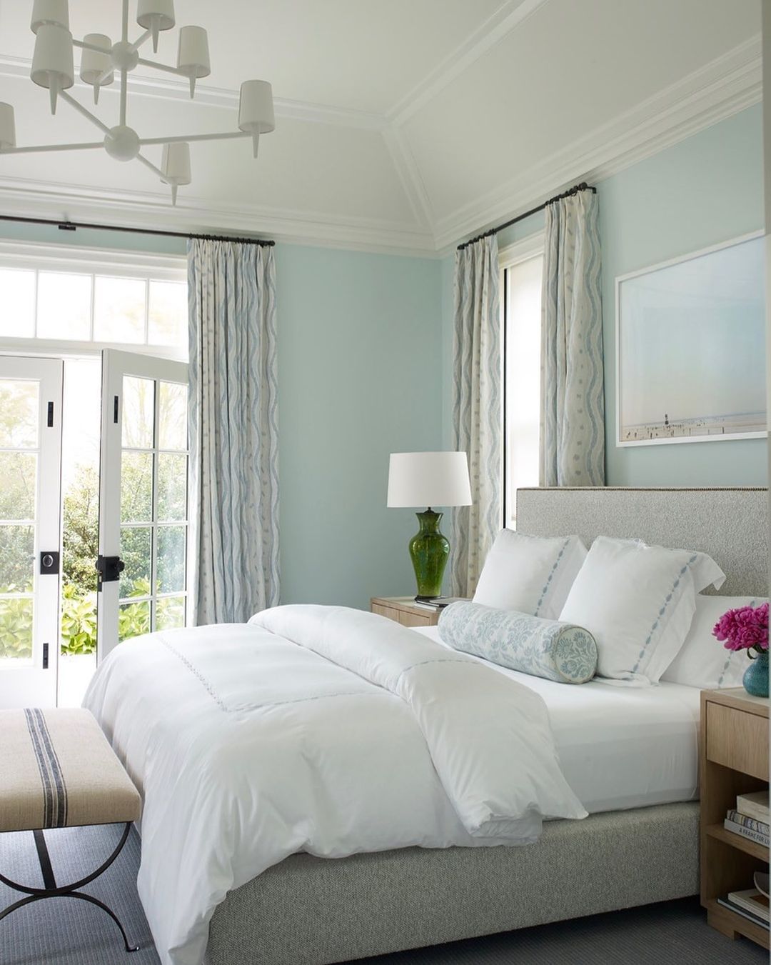 Inviting, white bed in a seafoam-colored bedroom in the Hamptons.