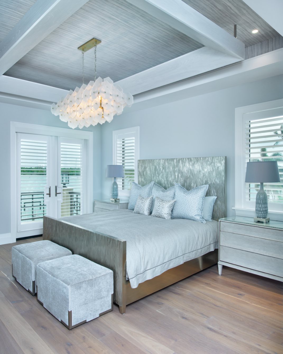 Photo of large, open bedroom with light hardwood floors and sky blue walls.