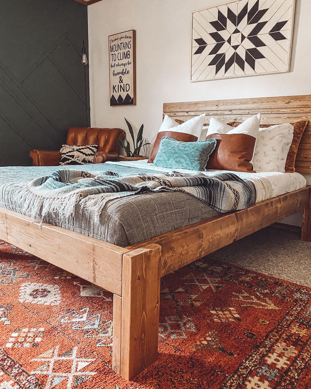 A bed in a homemade wooden frame and headboard. Photo by Instagram user @builditthrifty.