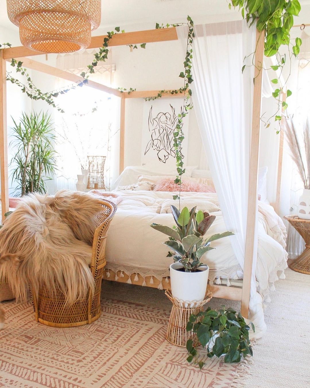 Light wood canopy bed in a bright Bohemian styled bedroom. Photo by Instagram user @dreaming_of_decor