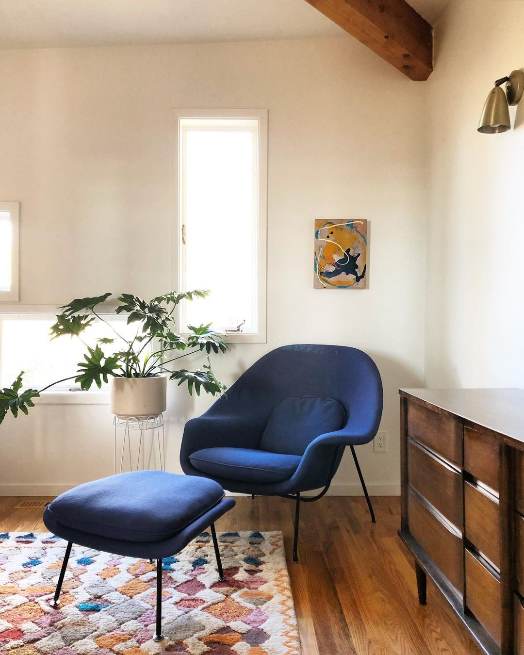 Dark blue womb chair in the corner of a bedroom. Photo by Instagram user @postandbeamliving