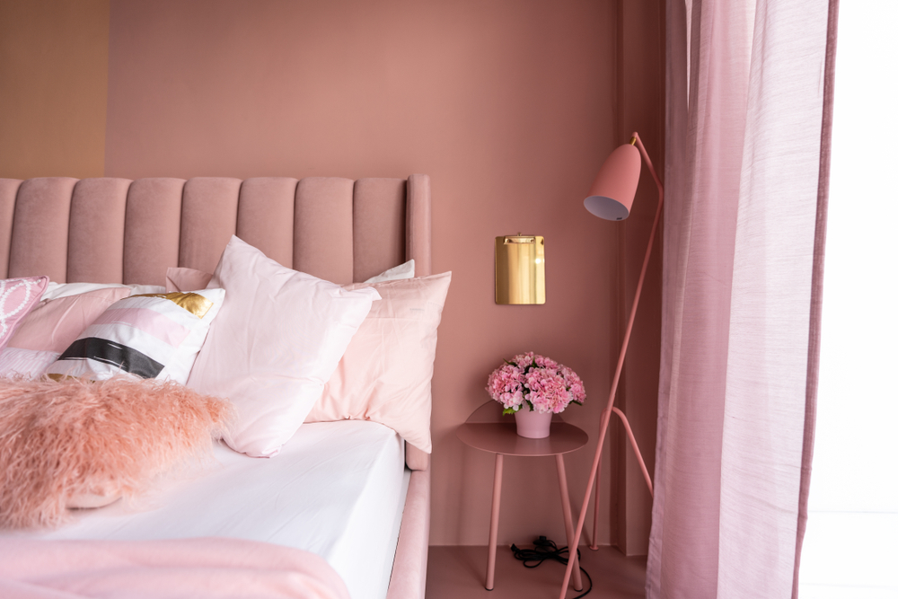 Updated bedroom with pink walls and pink accent furniture.