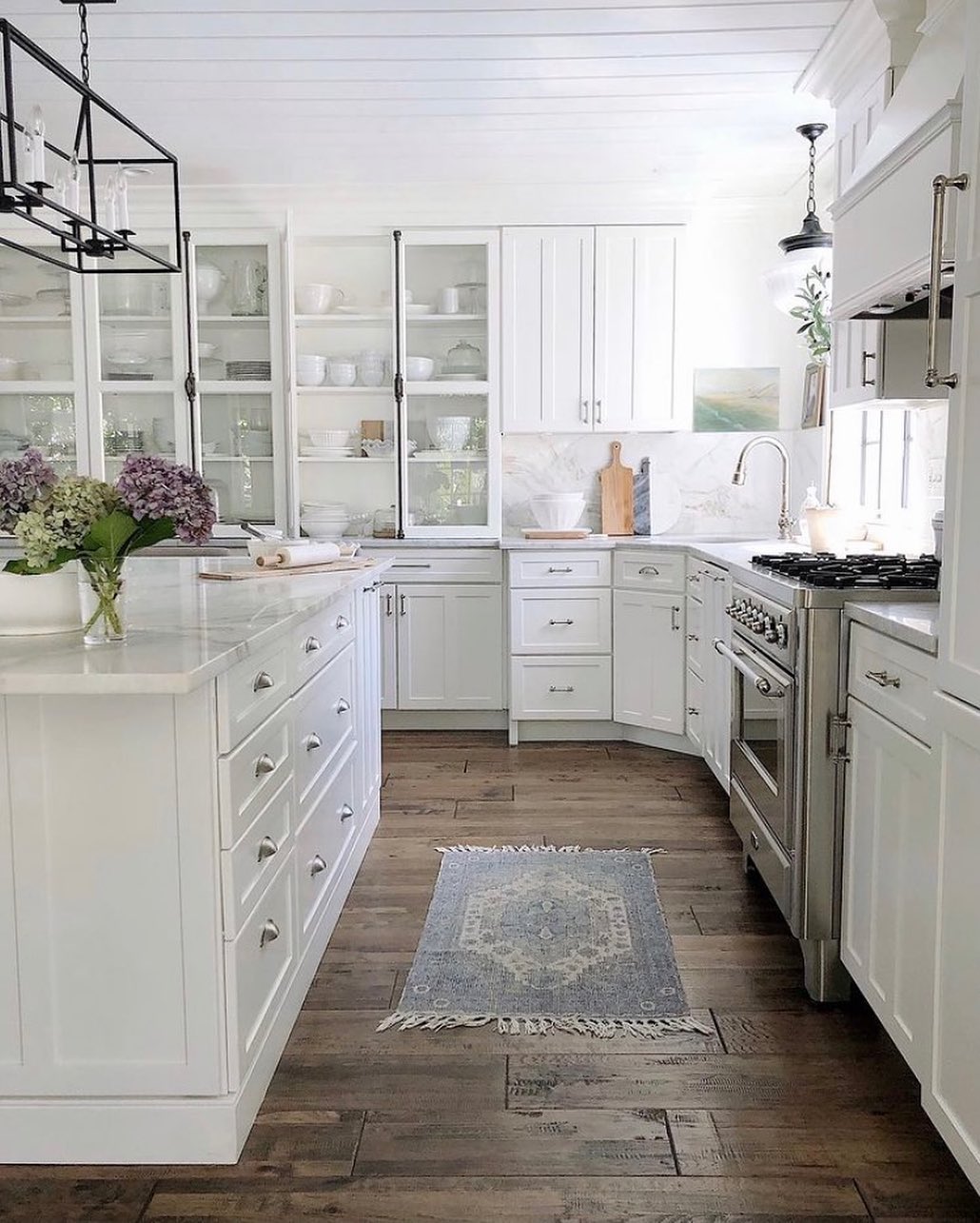Dark brown hardwood flooring in a white kitchen. Photo by Instagram user @ellyathome
