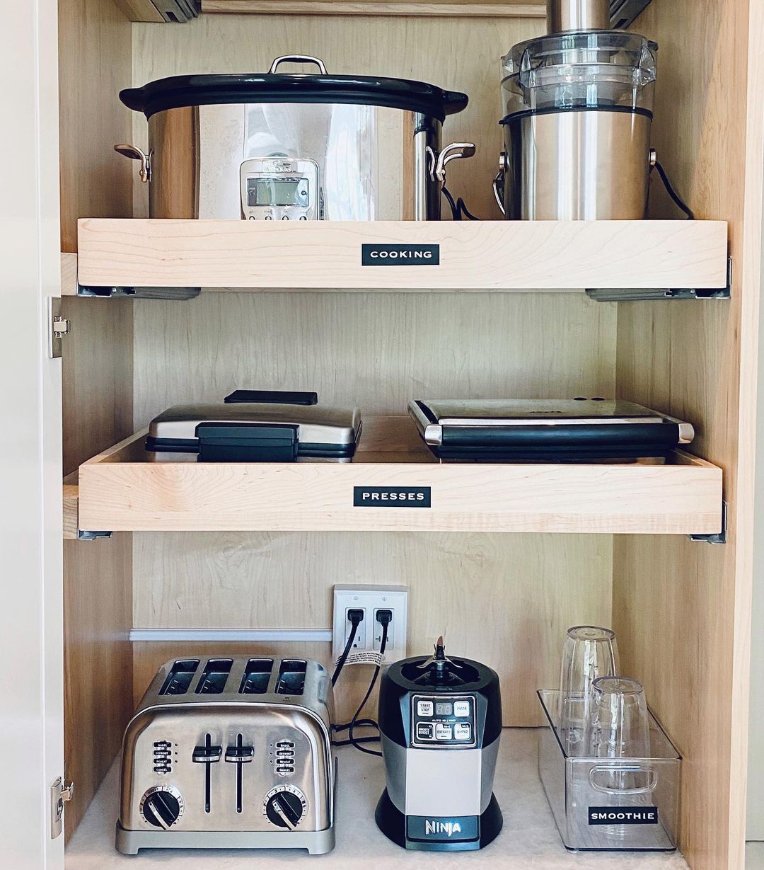 Kitchen cabinet with a slow cooker, blender, toaster, and other small kitchen appliances. Photo by Instagram user @chicly_organized