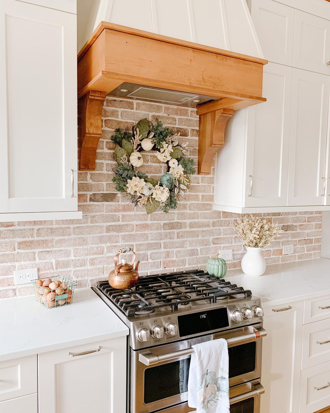 Gas stovetop in a white kitchen with brick backsplash. Photo by Instagram user @home_on_providence_hill