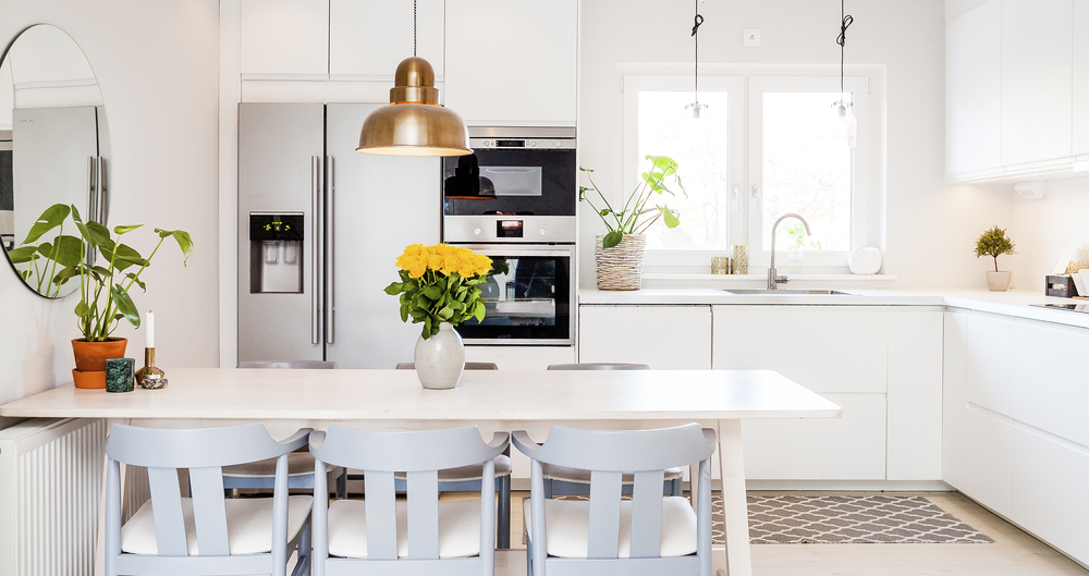 Clean white kitchen with dining table