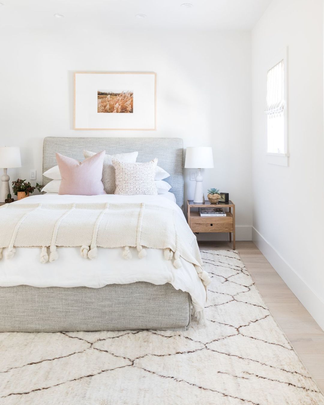 Bedroom with hardwood floors and large area rug. Photo by Instagram User @mindygayerdesign