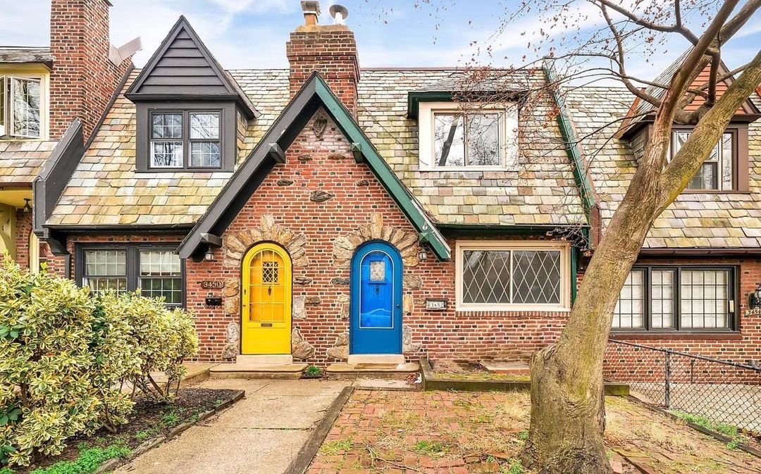 Restored twin home in East Falls neighborhood of Philadelphia with one yellow door and one blue door. Photo by Instagram user @keepitrealestatephilly.