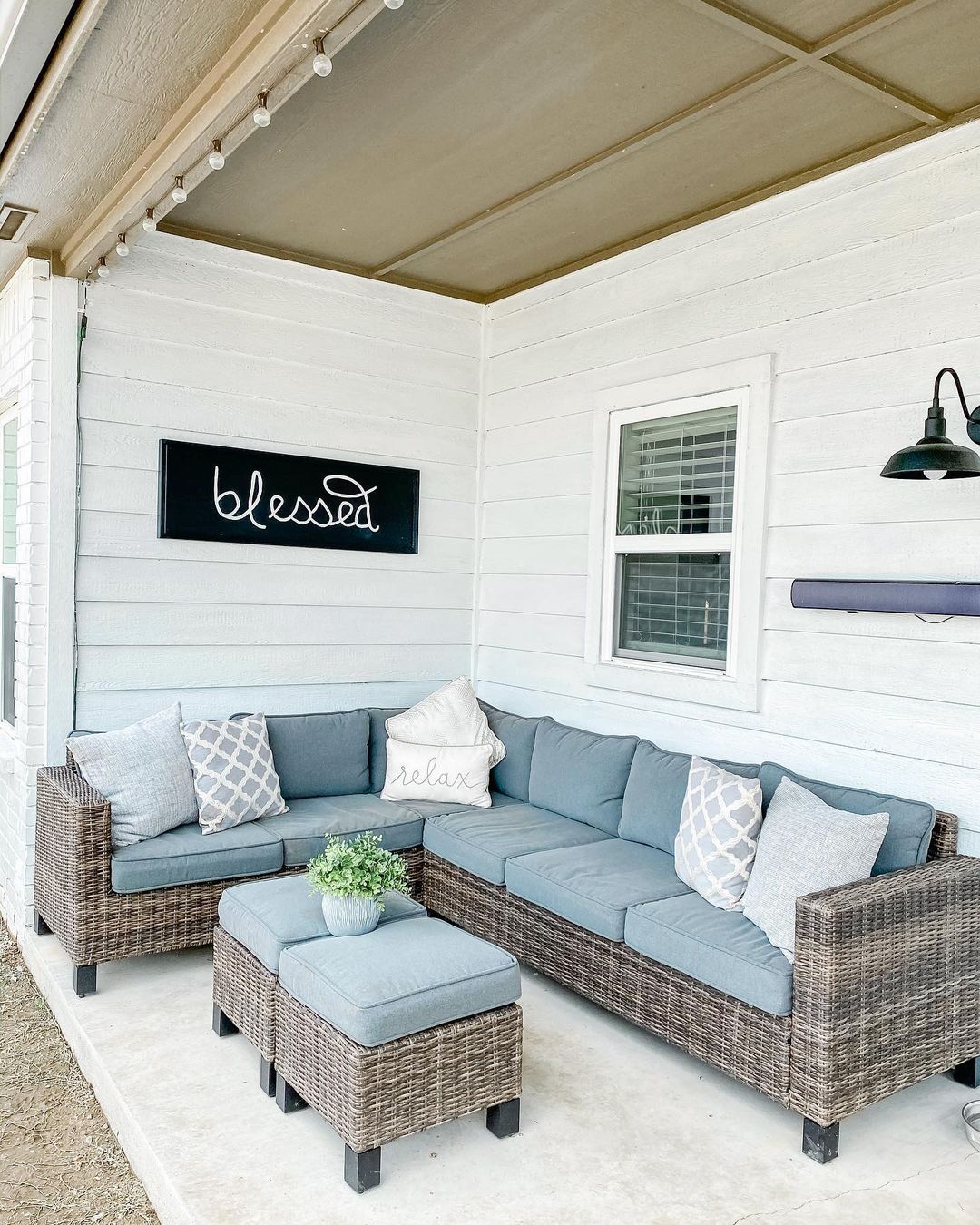 Outdoor Farmhouse Patio with a Wicker Sectional in the Corner. Photo by Instagram user @tilvacuumdouspart