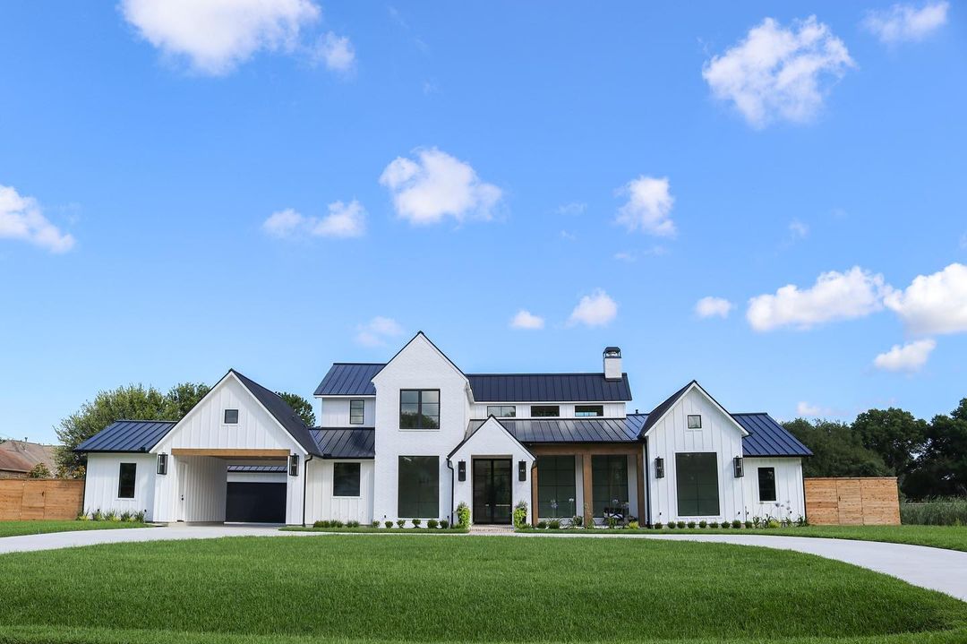 White Farmhouse with a Black Metal Roof. Photo by Instagram user @triplecfarmhouse