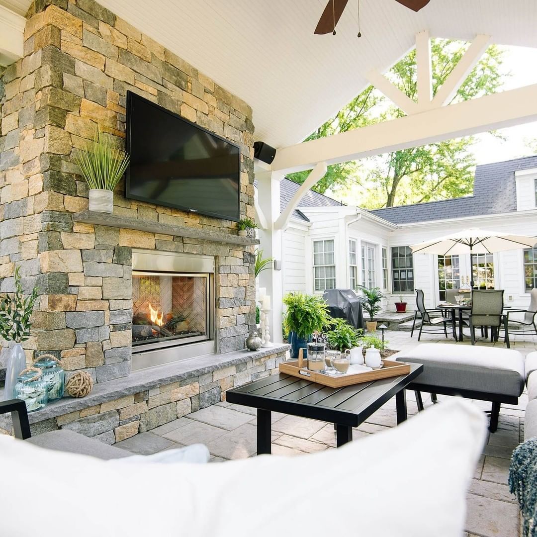 Backyard Hangout Space with TV Mounted Above Fireplace. Photo via @outdoordreams
