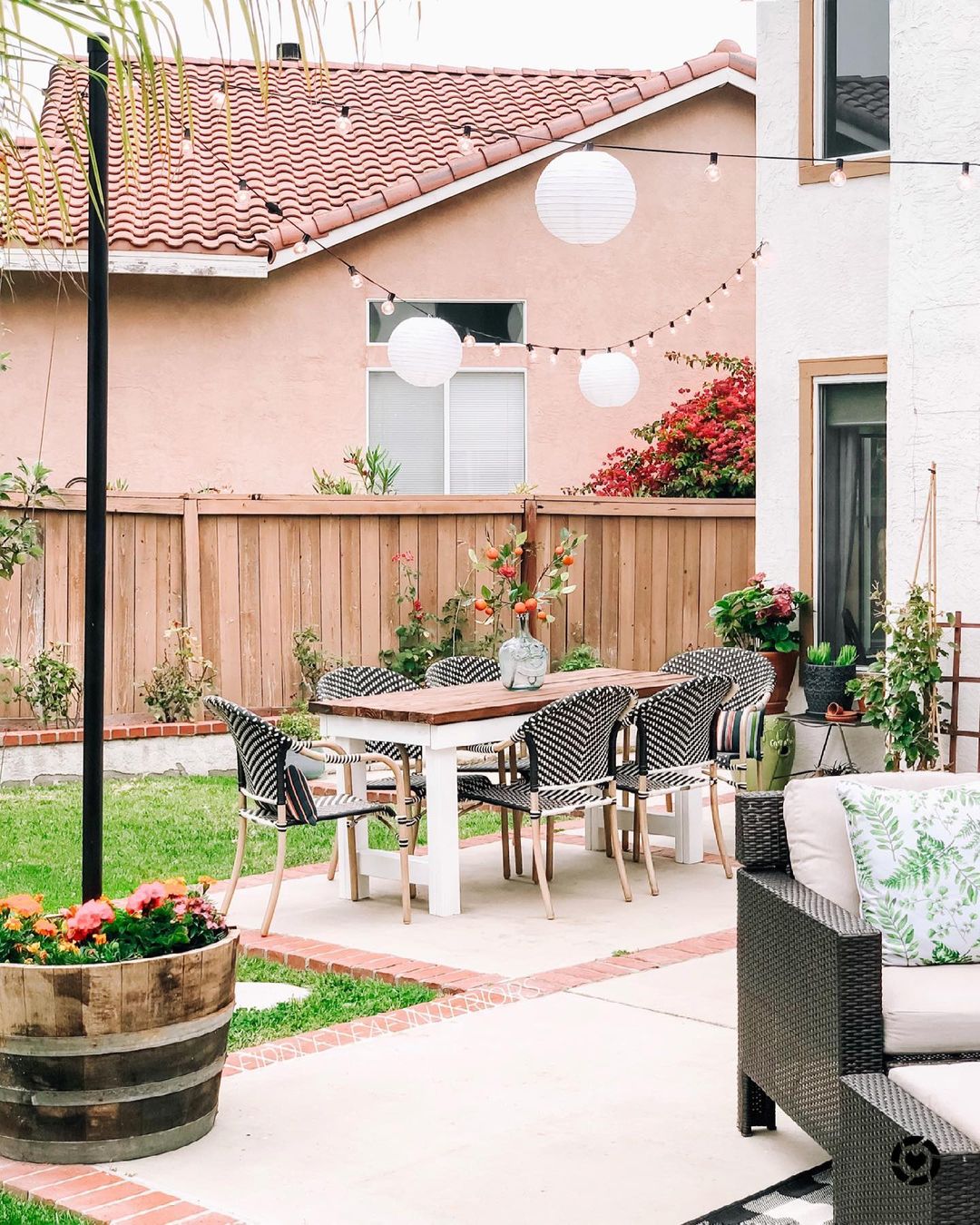 Backyard Patio Space with String Lights Hanging Over a Dining Table. Photo by Instagram user @fiddleleafinteriors