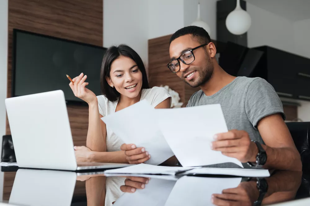 Couple Sitting Together at a Desk Looking at Papers