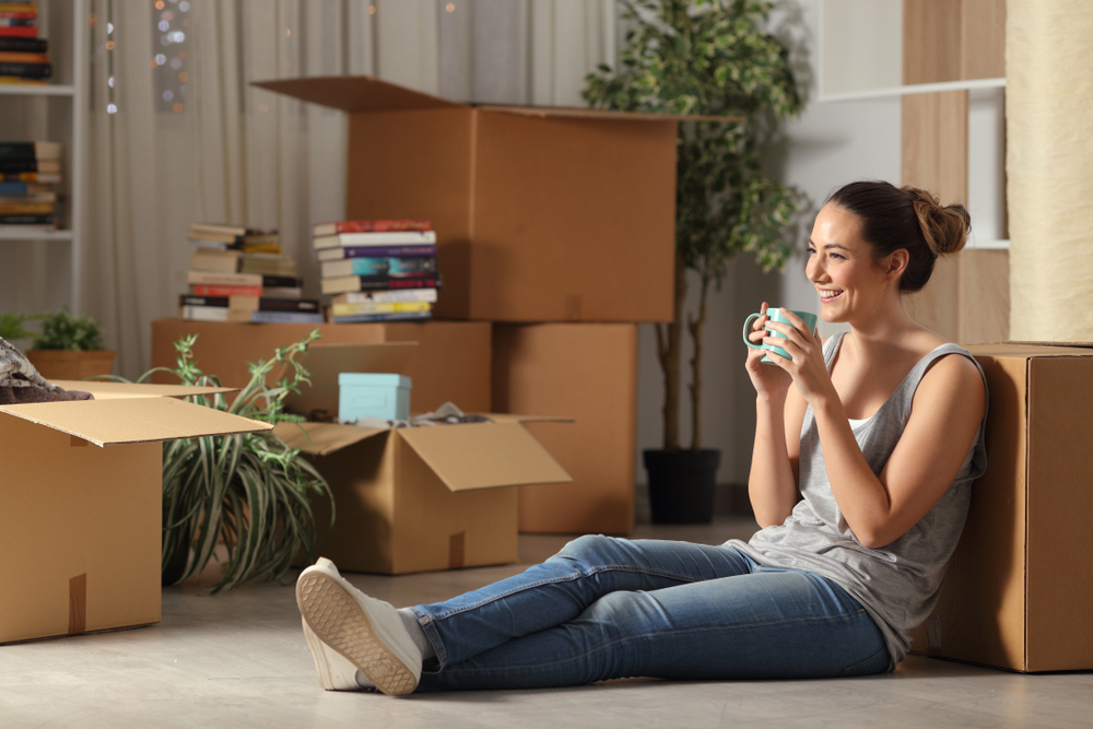 Woman Sitting on the Floor Among Moving Boxes