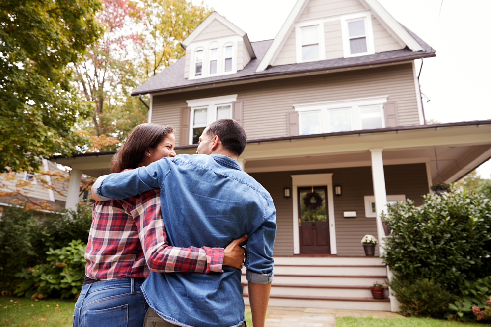 Man and Woman Standing Together Outside of a Home