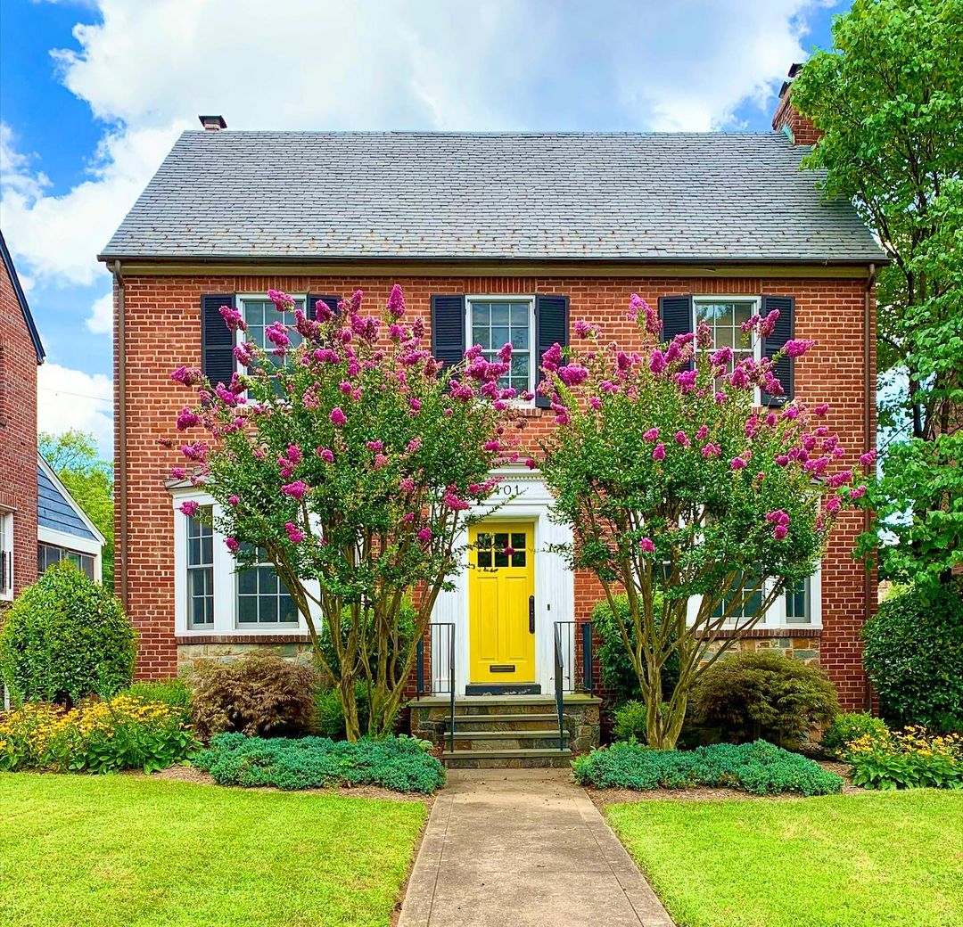 Brick estate home with bright yellow door and well-maintained landscape in Brightwood neighborhood of Washington, DC. Photo by Instagram user @artyomshmatko. 