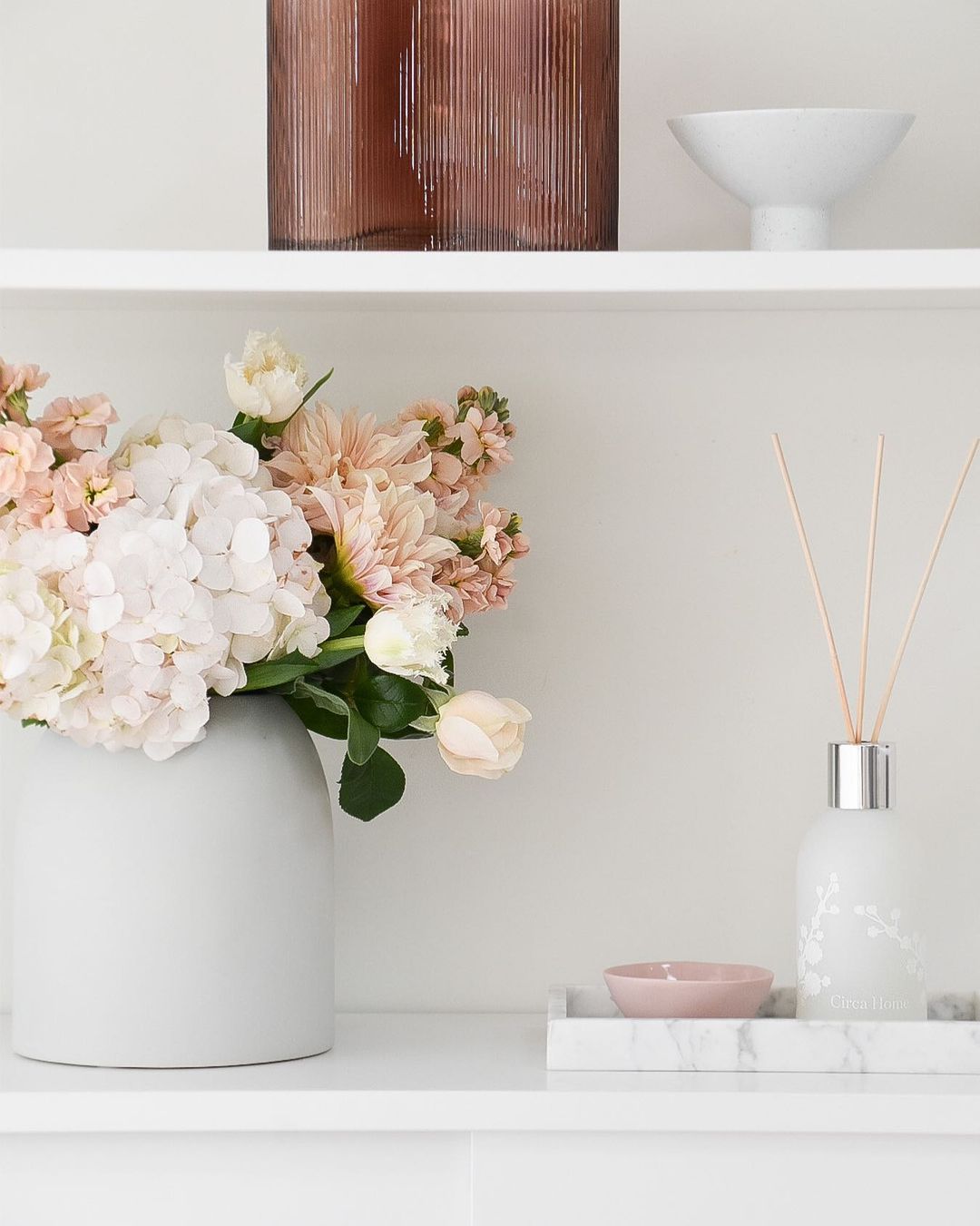Shelf with Flowers and Oil Diffuser. Photo by Instagram user @coco.camellia_